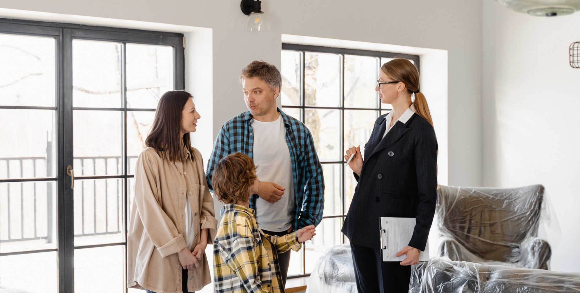 Familia recorriendo una vivienda en Miami con su asesora inmobiliaria
